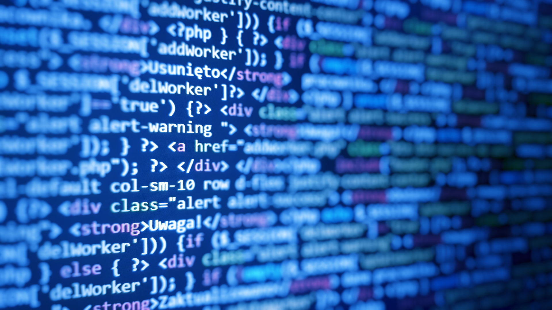 Close-up of computer code on a blue screen, representing AI-powered scams targeting patient data in medical practices
